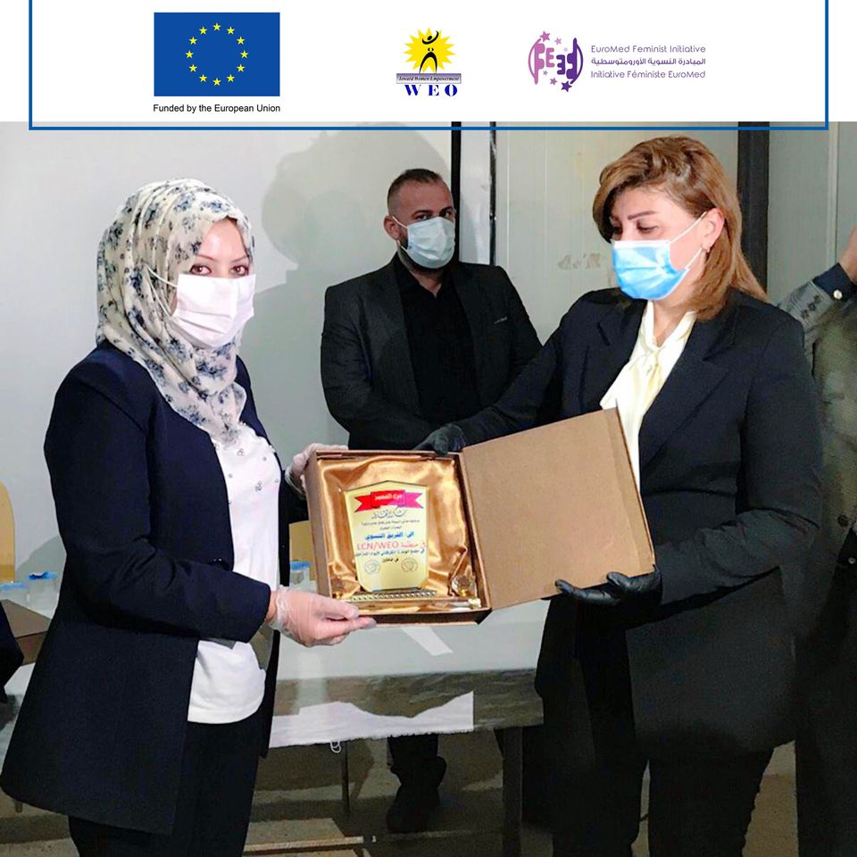 Mrs. Evan Faek, Minister of Immigration and Displaced to the IDP camps in Khanaqin, presents a shield of Excellence to the staff of WEO